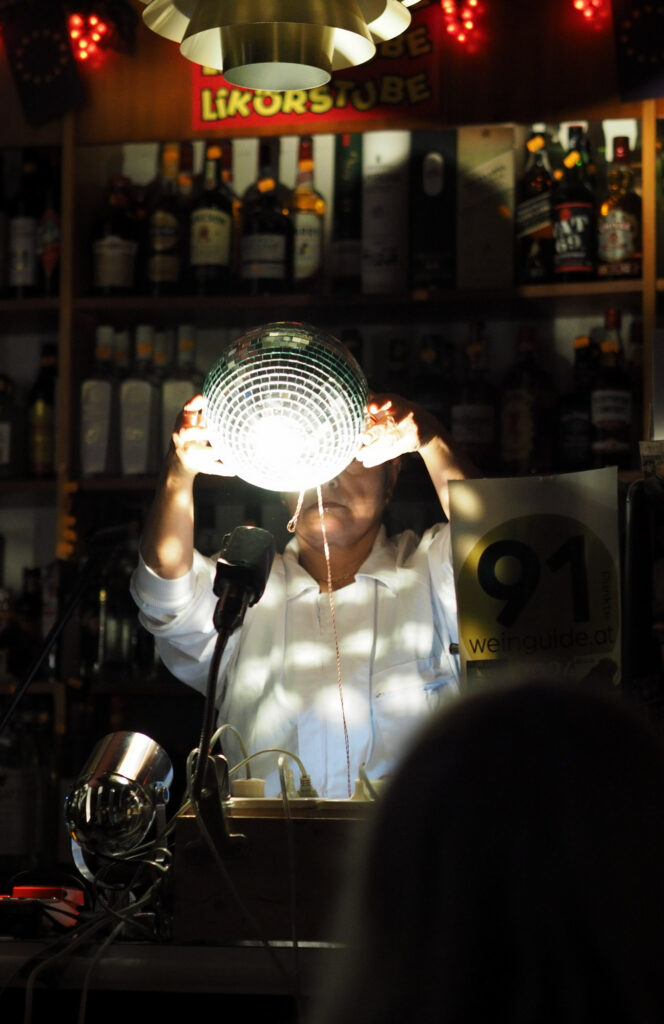 Sabine Marten hält während der Performance in Transdanubien eine glitzernde Diskokugel hoch.