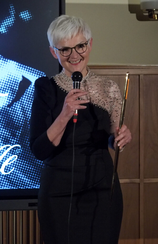 Maria Rösslhumer freut sich sehr über die Würdigung. In ihrer linken hält sie den Preis: eine große, goldene Nadel.